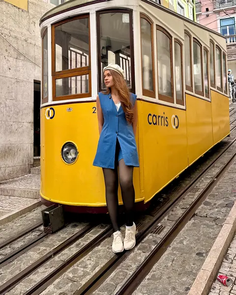 Ju na frente do bondinho amarelo do Elevador da Bica, em Lisboa