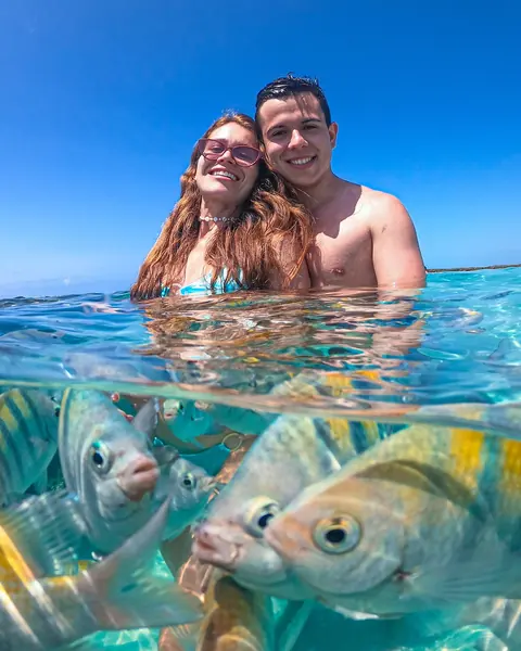 Ju e Ney no mar de Maragogi, com peixes listrados embaixo d'água